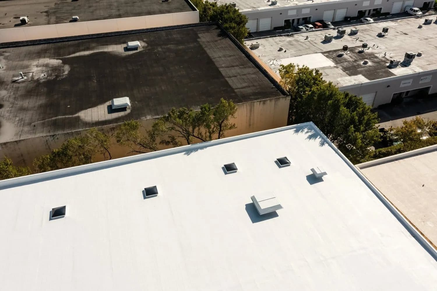 Aerial view of a commercial flat roof with a parking lot