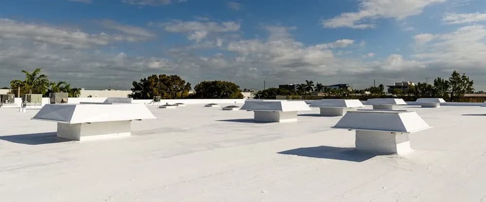 Aerial view of a commercial white flat roof with rooftop HVAC units