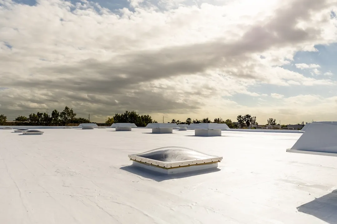Flat white roof with a skylight dome and rooftop equipment
