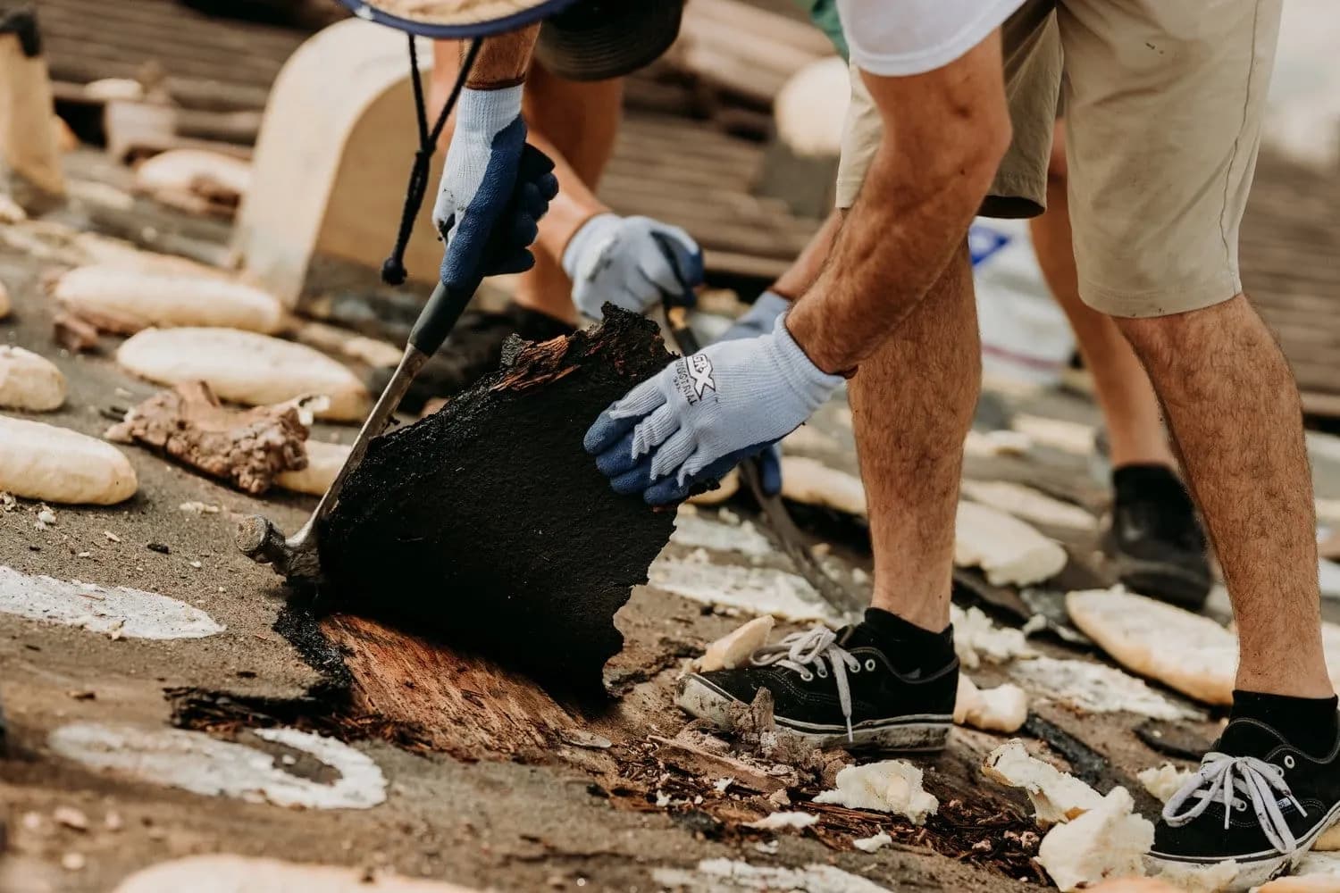 Roofer removing damaged roof tiles during a repair