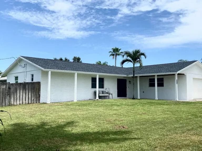 Single-story white home with a gray architectural shingle roof