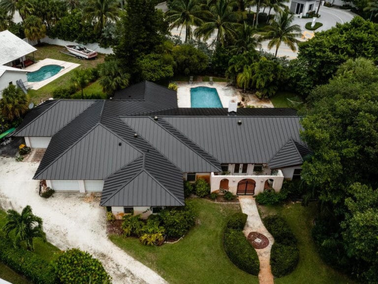 Aerial view of a home with a new standing seam metal roof installed by All-Type Roofing Services